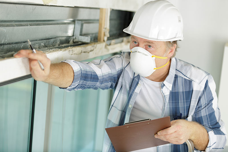 elderly man with face mask inspecting property